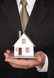 Top 10 tips to prepare your finances for a home loan (Man in suit holding house)