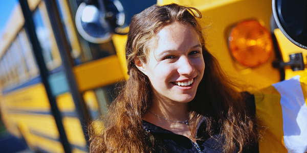 Student Standing by School Bus