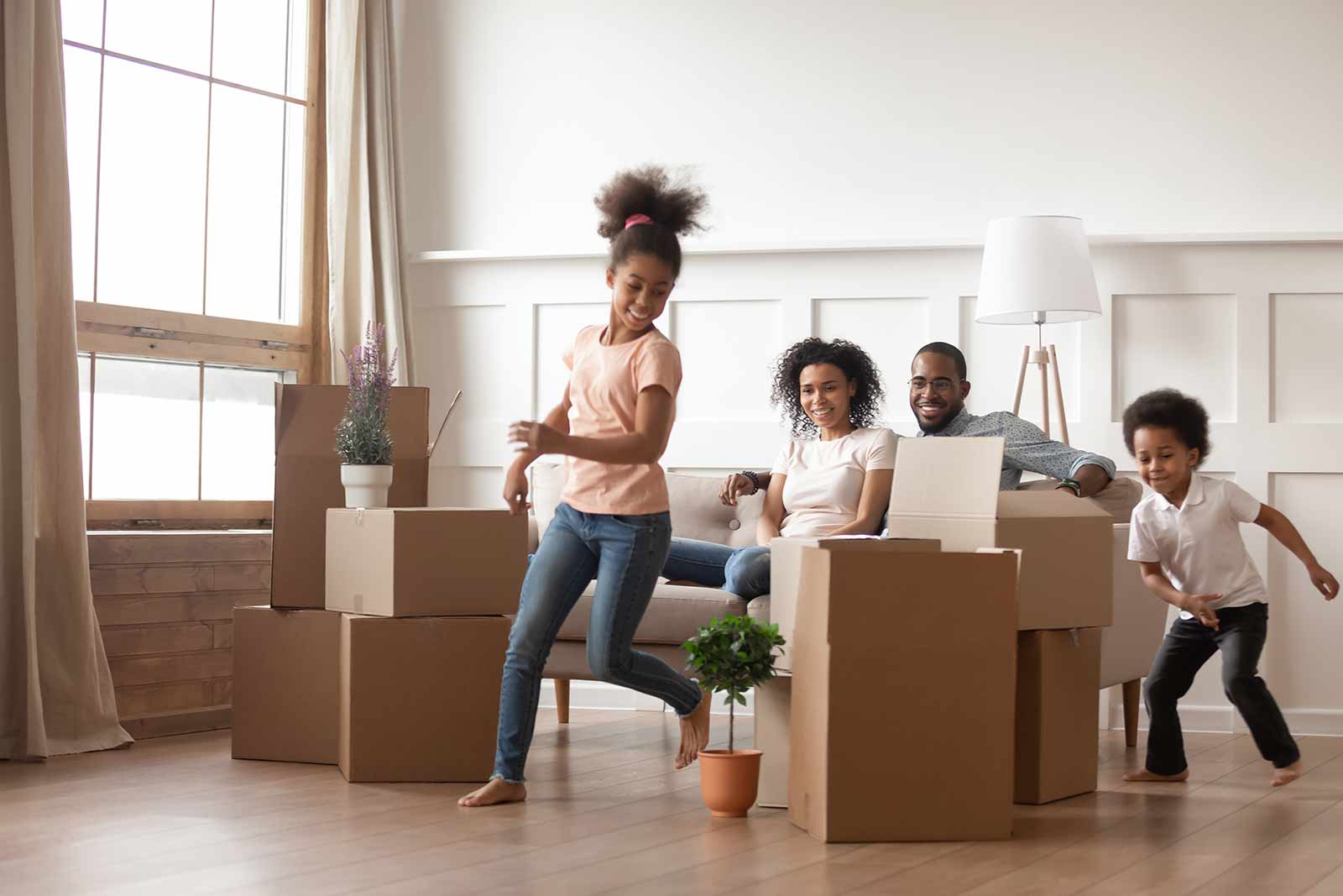 Offer accepted, now what?  Happy Family in their own house surrounded by moving boxes.