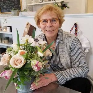 Sue lusk holding a pot of flowers.