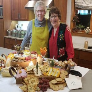 sue lusk standing with person in kitchen during a holiday setting.