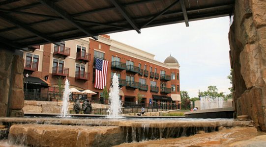 downtown gahanna, featuring sidewalks, a fountain, and brick buildings.