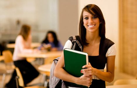 Girl standing in cafeteria holding book