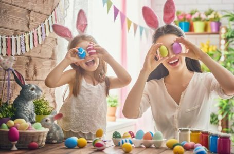 mother and daughter coloring Easter eggs with rabbit ears.